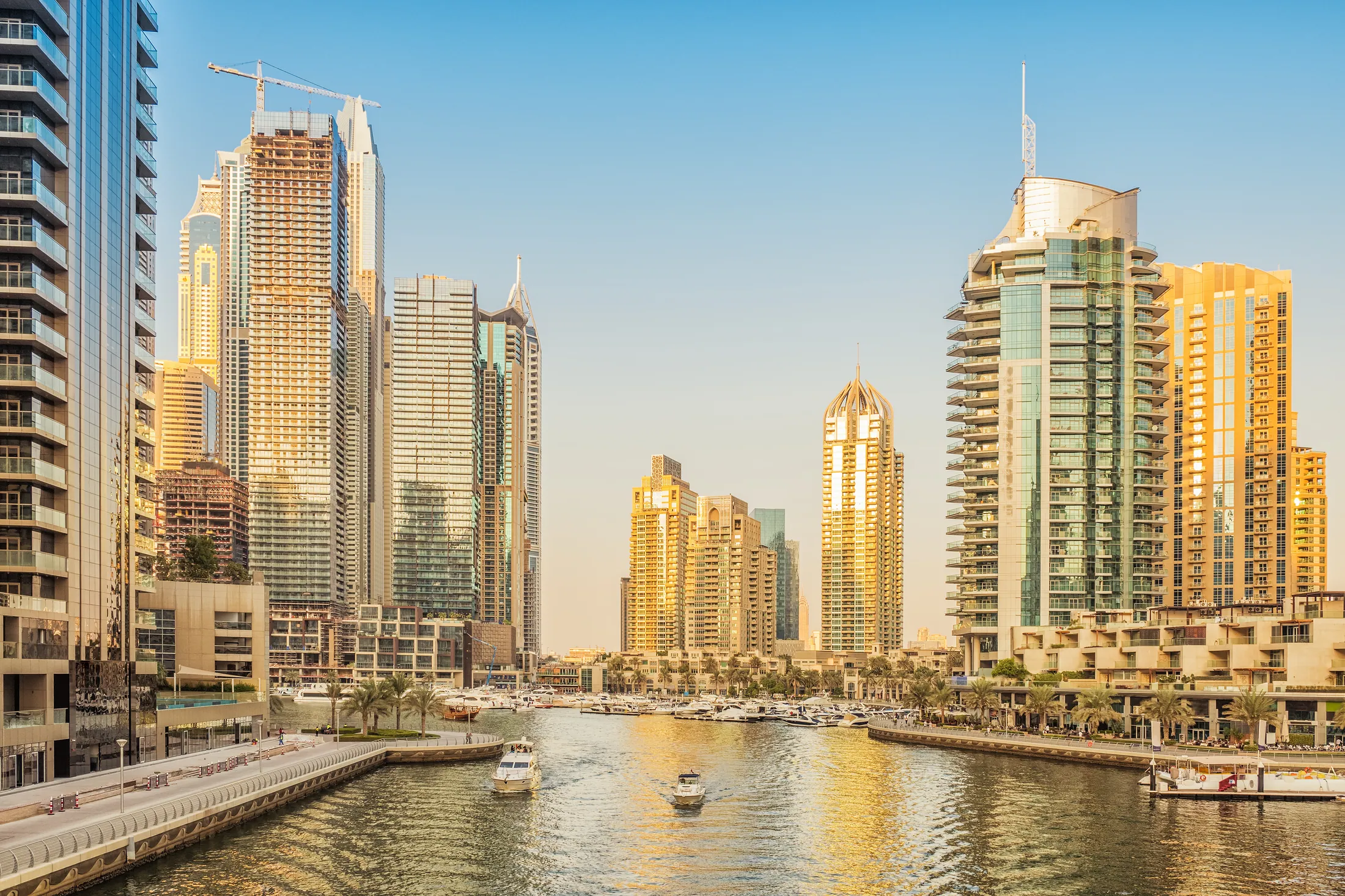 Dubai Marina waterfront with towers, boats, and promenade