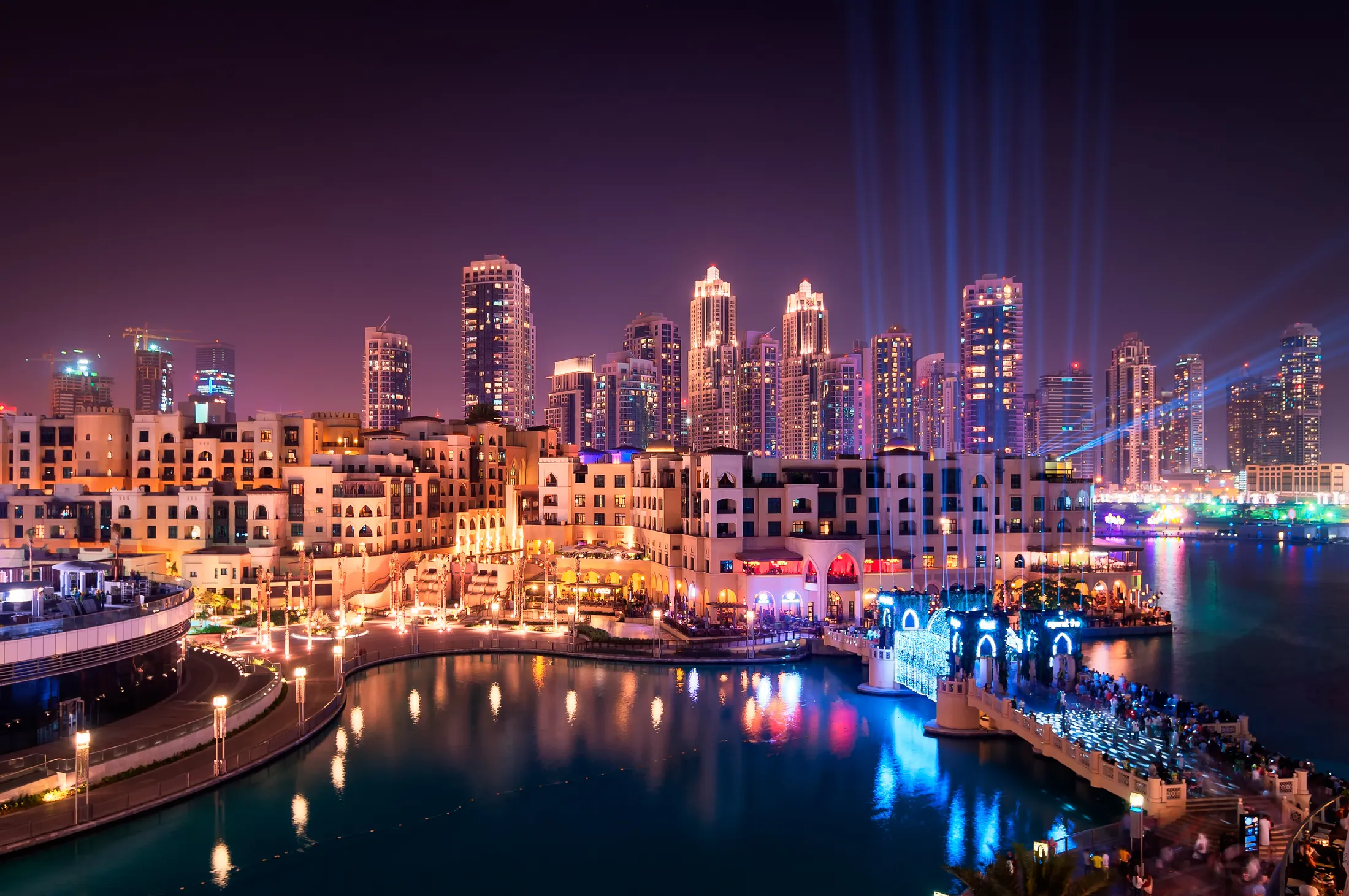 Downtown Dubai illuminated at night beside the waterfront